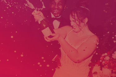 bride and groom popping champagne with a purple red overlay